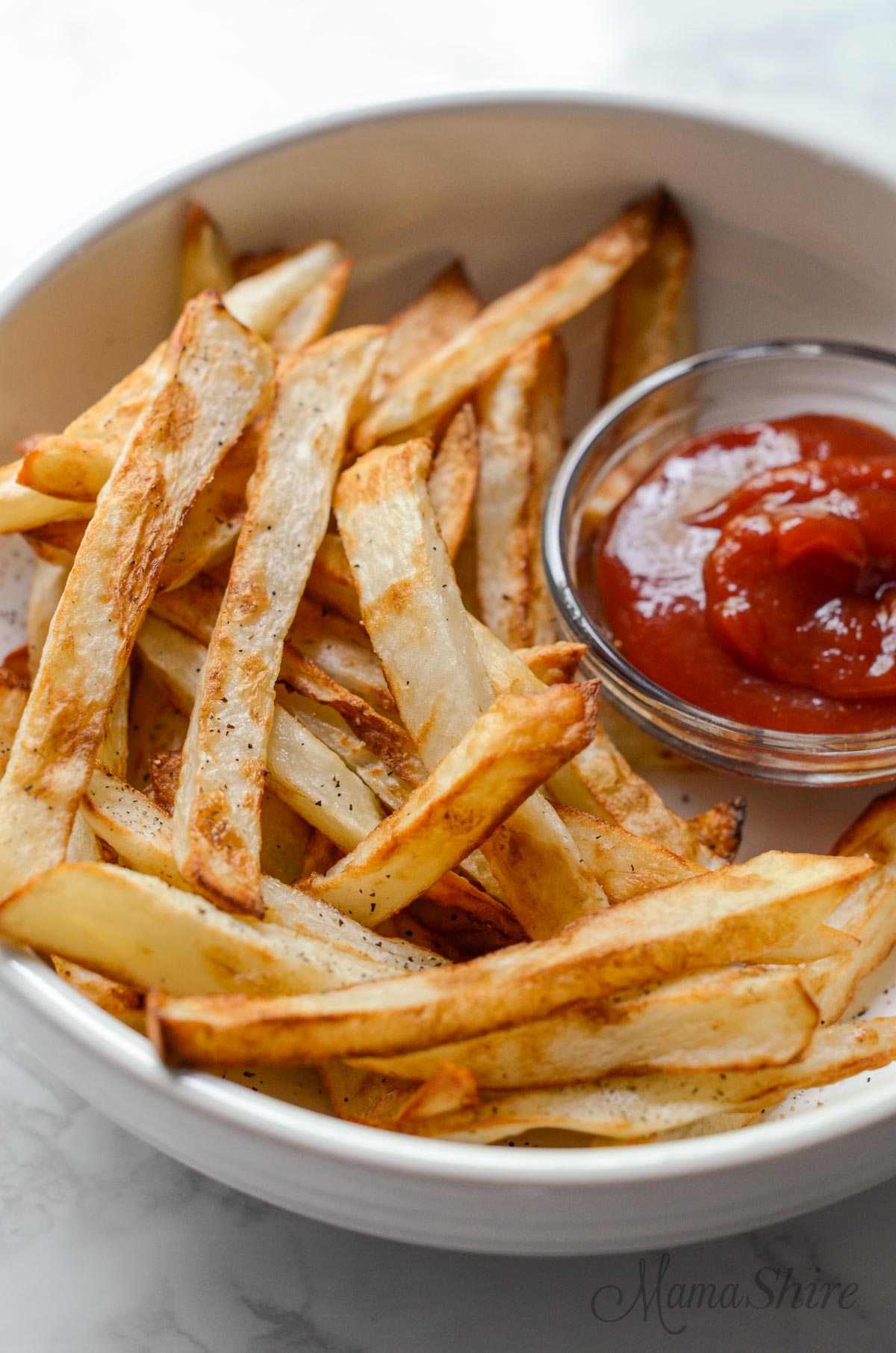 Homemade french fries made in an air fryer served with ketchup.