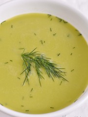 A bowl of asparagus leek soup in a white bowl.