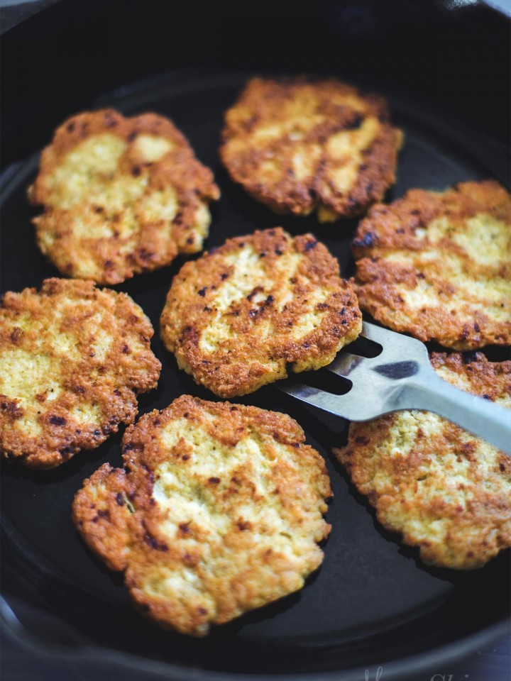 Homemade Chicken Patties frying in an iron skillet.