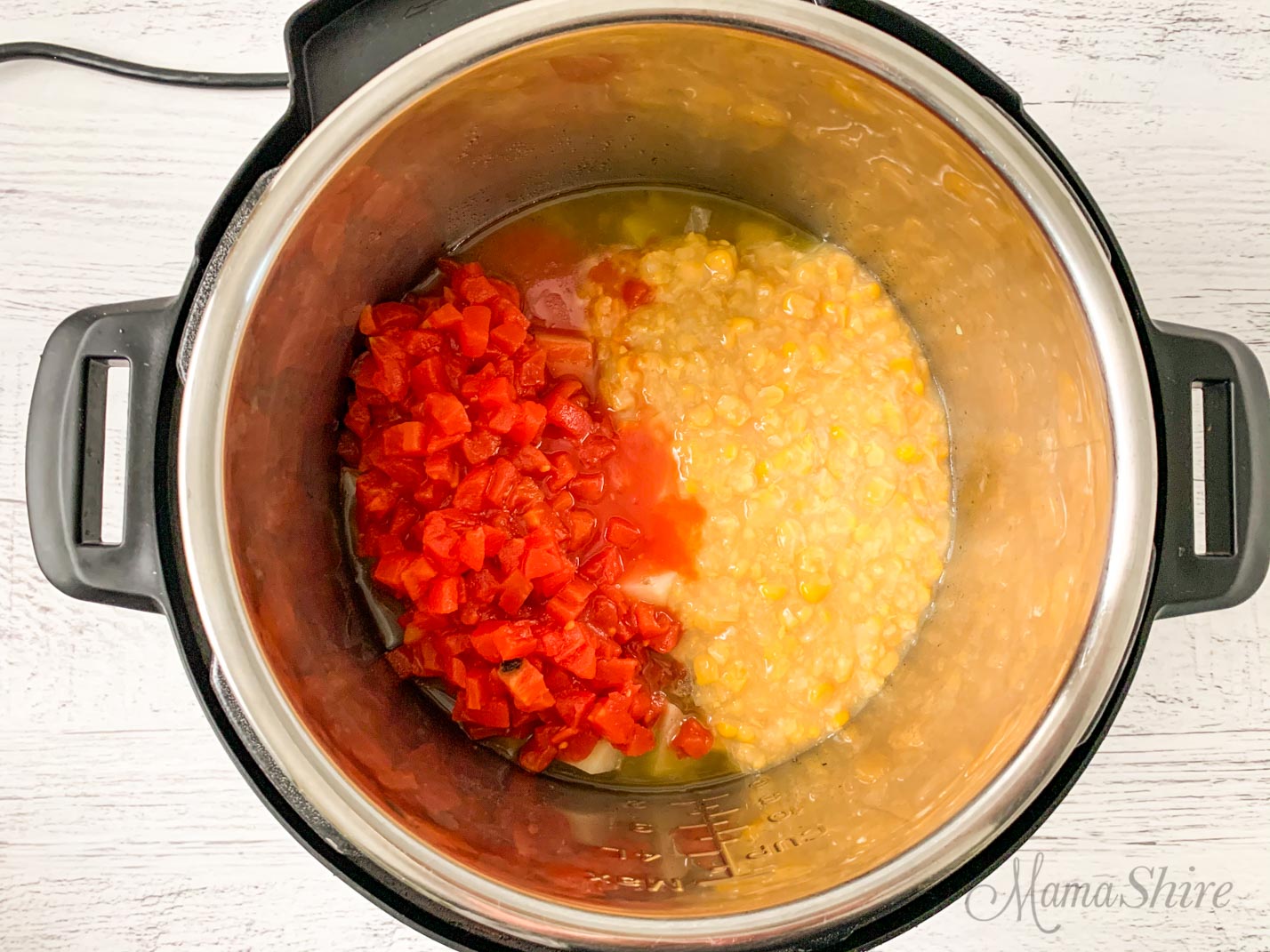 Diced tomatoes and creamed corn added to a pot a creamy hamburger soup. 