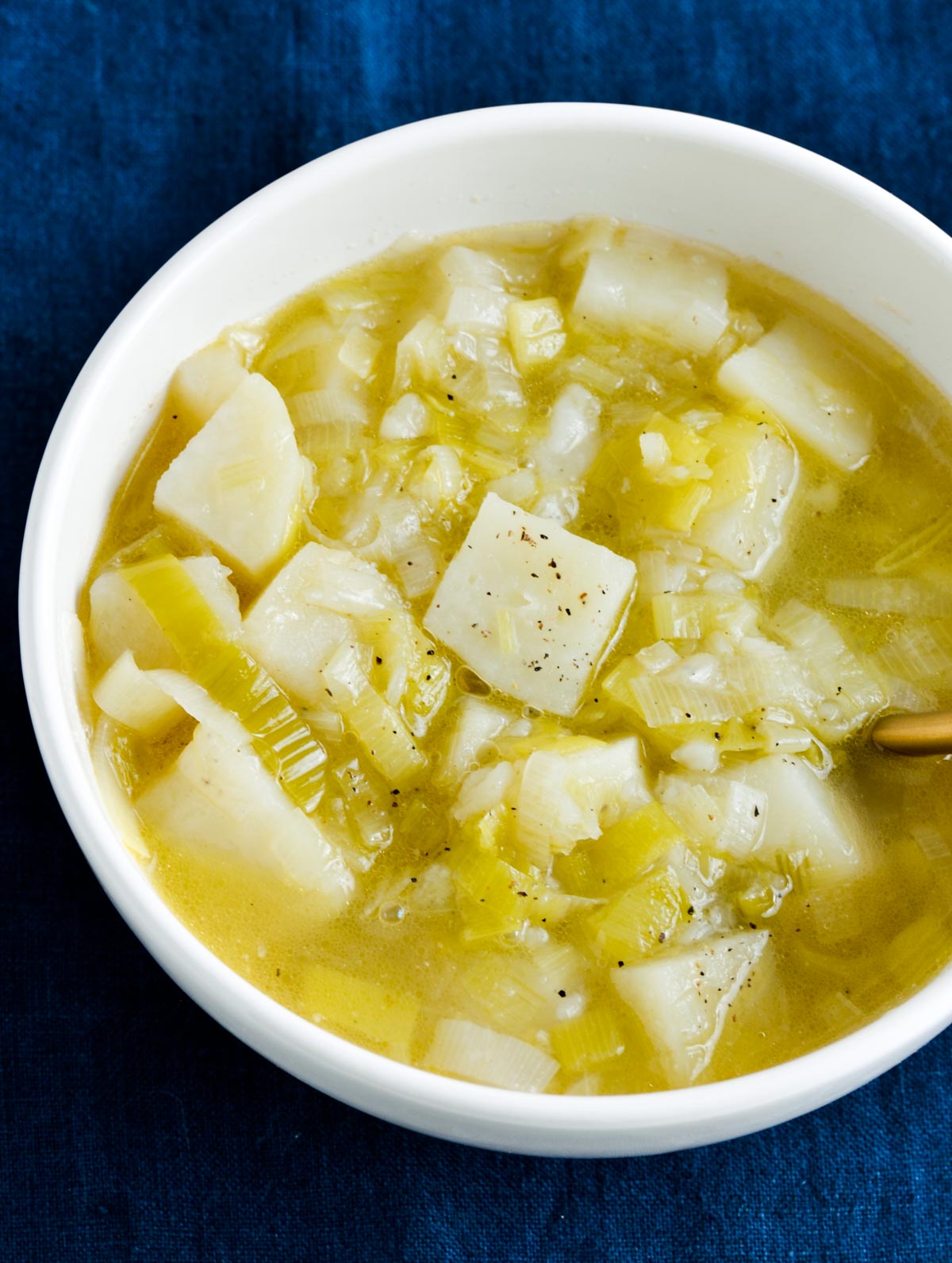 A bowl of leek and potato soup with chicken broth.