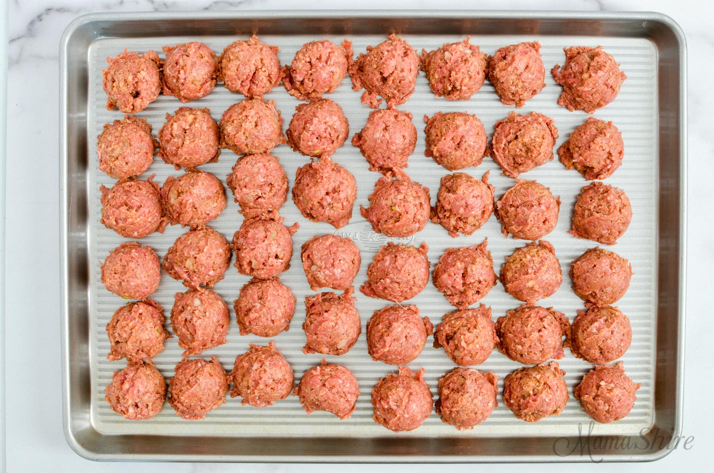 A pan of gluten-free meatballs ready to bake or freeze.