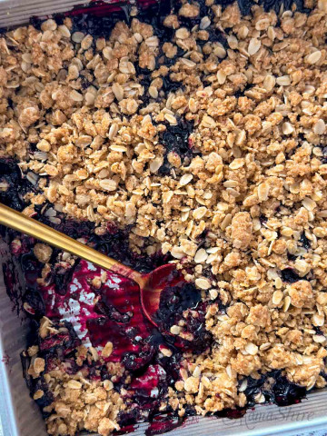 Gluten-free blueberry crisp with a serving removed.