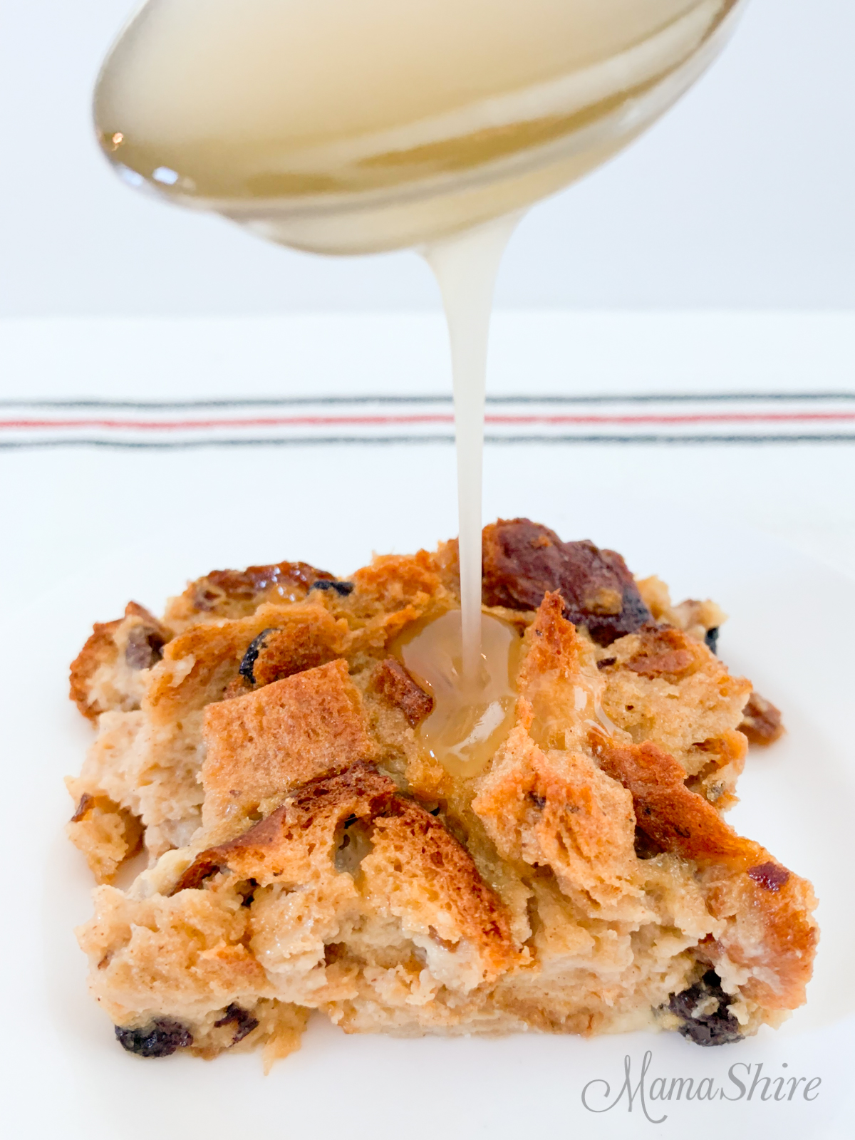 Gluten Free Bread Pudding with a vanilla sauce drizzling over the top.