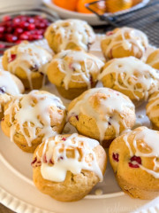 Gluten-free cranberry orange muffins on a white cake platter.