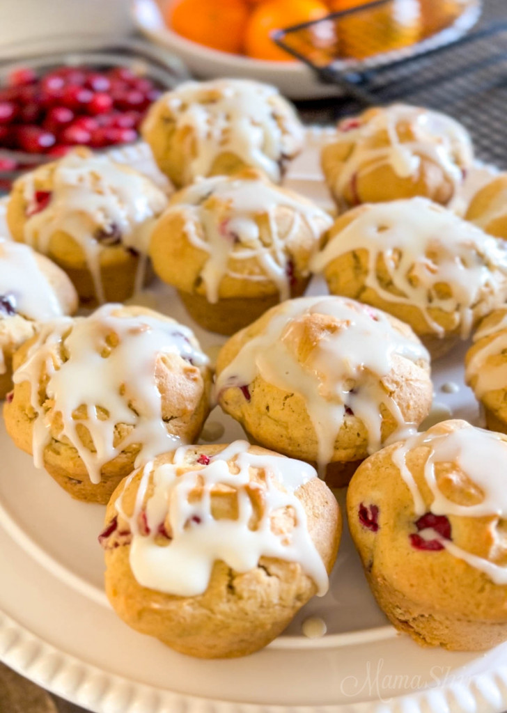 Gluten-free cranberry orange muffins on a white cake platter.