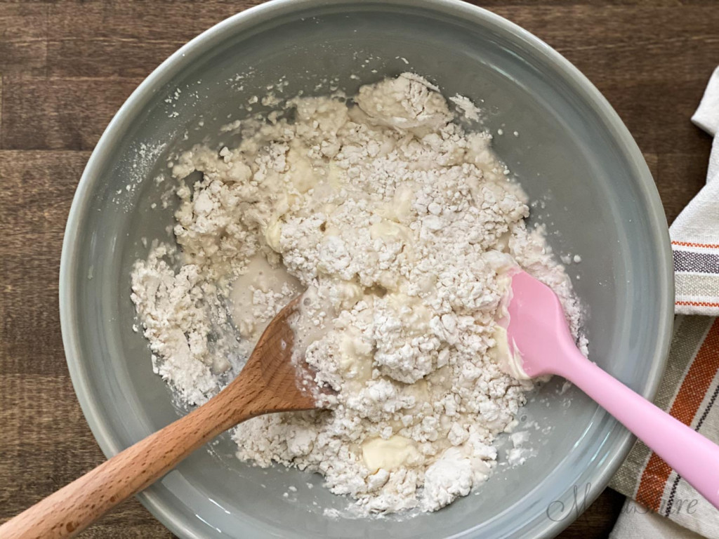 Mixing all the ingredients in a large grey ceramic bowl for gluten-free biscuits.