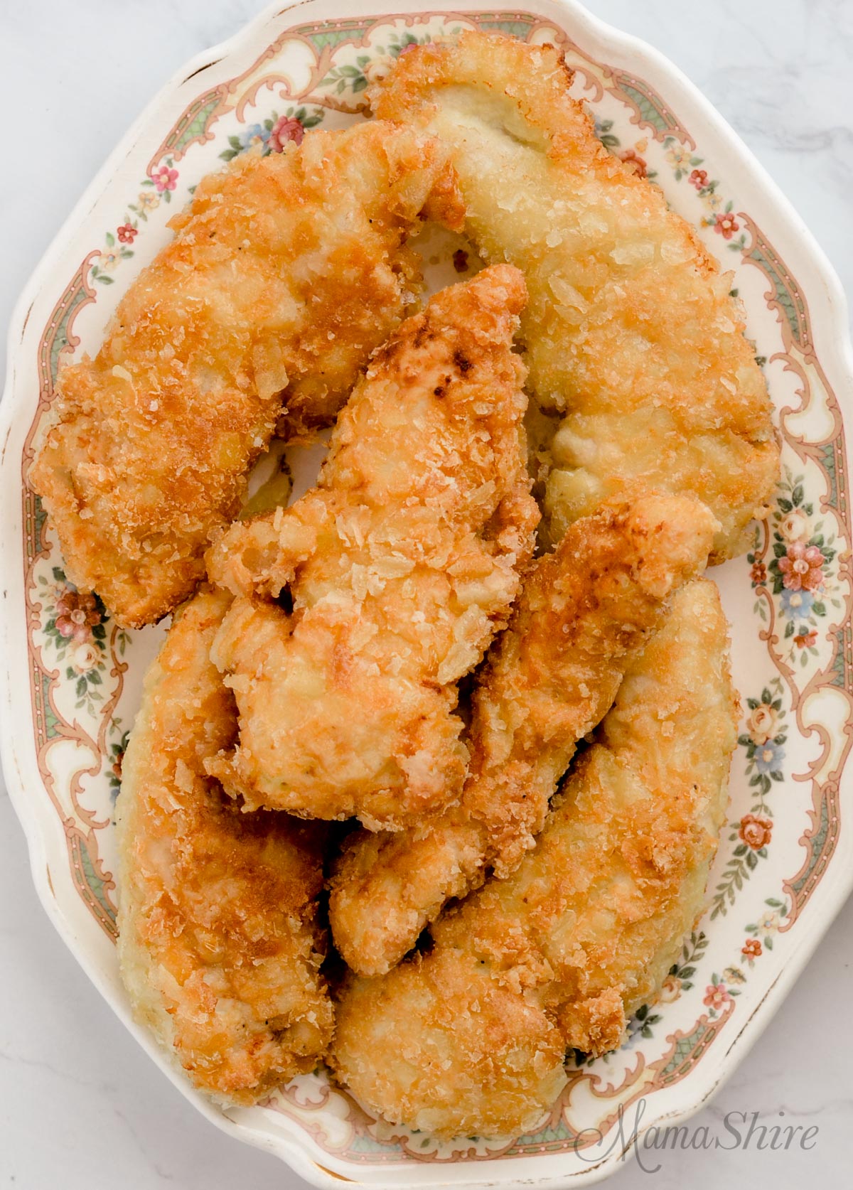 A plate of fried chicken made with a potato chip breading.