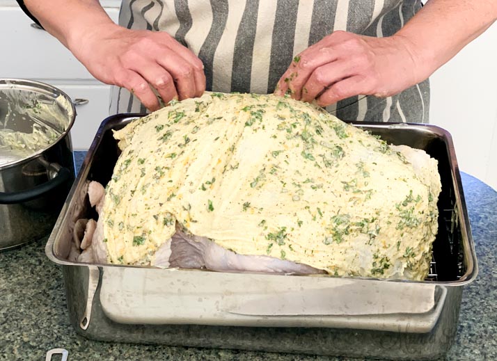 Dairy-free herbed butter soaked cheesecloth over a turkey.