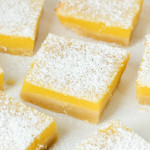 Squares of gluten-free lemon bars dusted with powdered sugar.