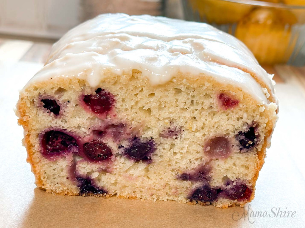 A sliced gluten-free lemon blueberry loaf showing the blueberries in the bread.