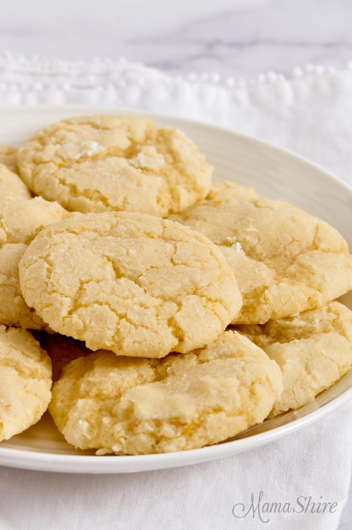 A white serving plate filled with gluten-free lemon cookies.