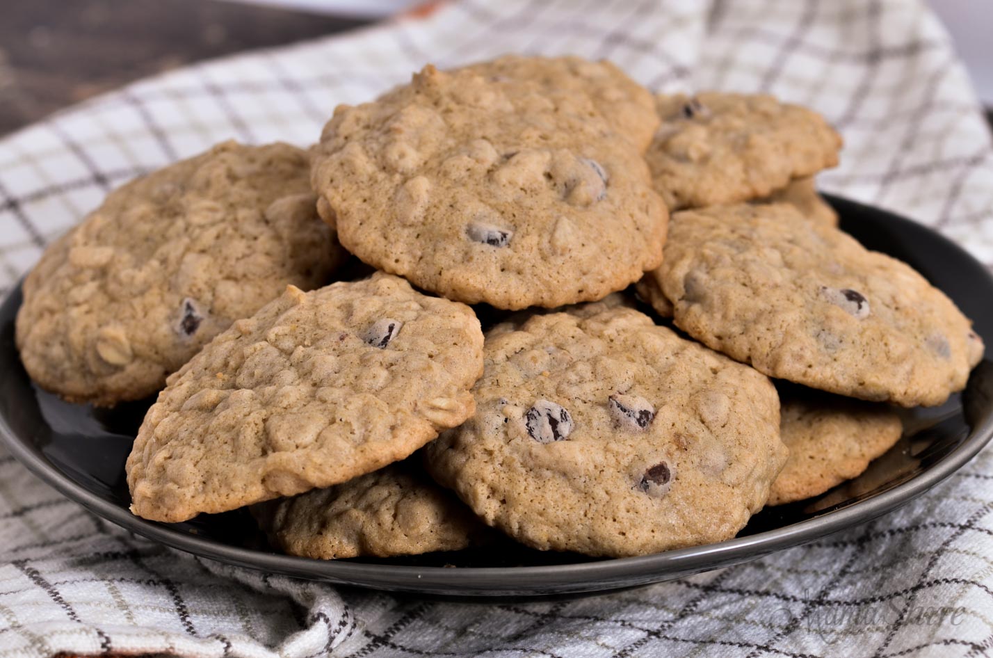 Oatmeal cookies with chocolate chip cookies on a black plate.