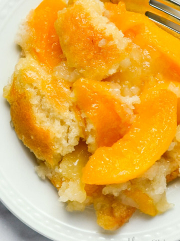 A serving of gluten-free peach cobbler on a white plate.