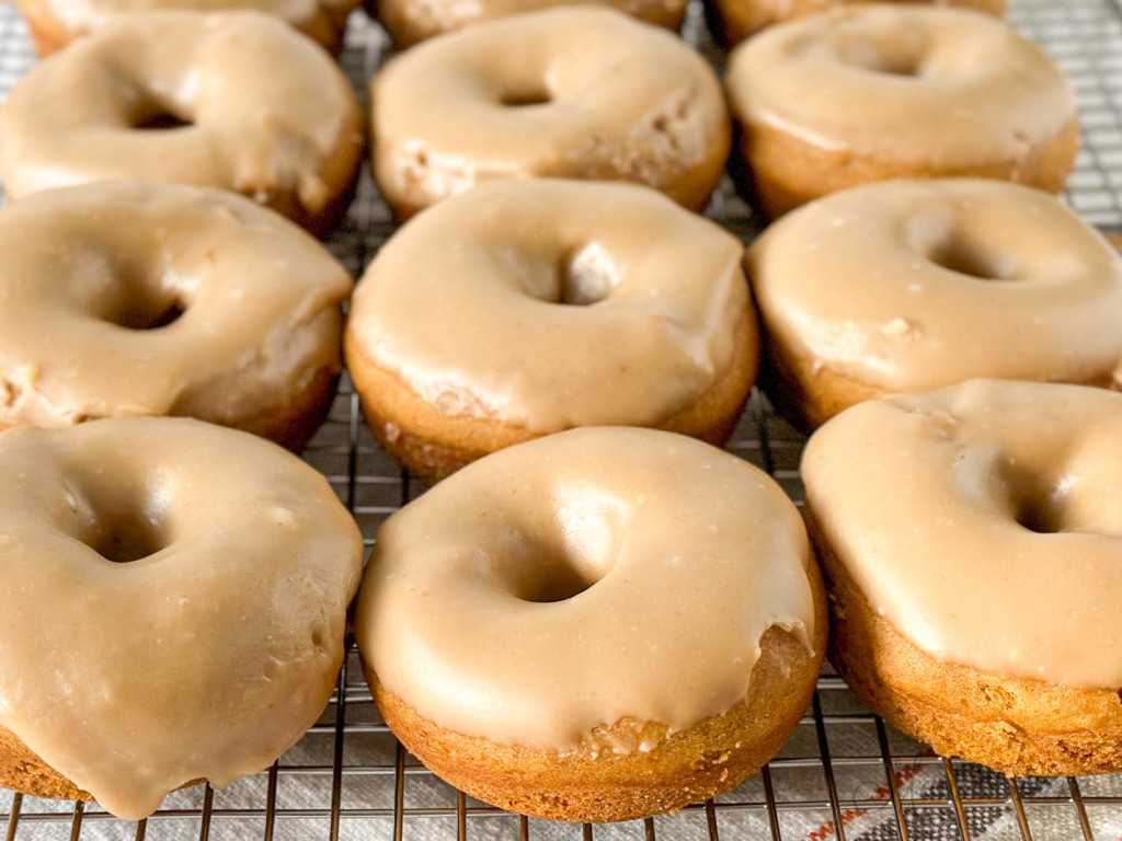 Baked gluten-free pumpkin donuts with brown sugar icing.