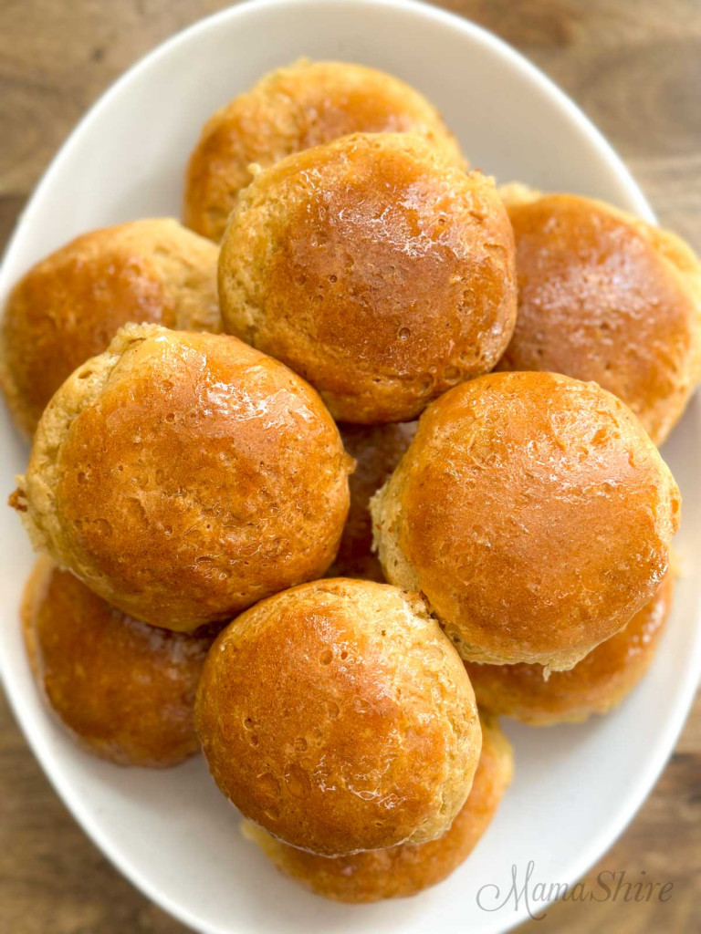 A platter of gluten-free yeast rolls with dairy-free honey butter spread on top. 