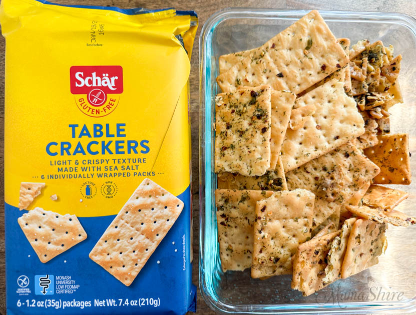 A package of Schar brand crackers and a glass container of hot crackers.