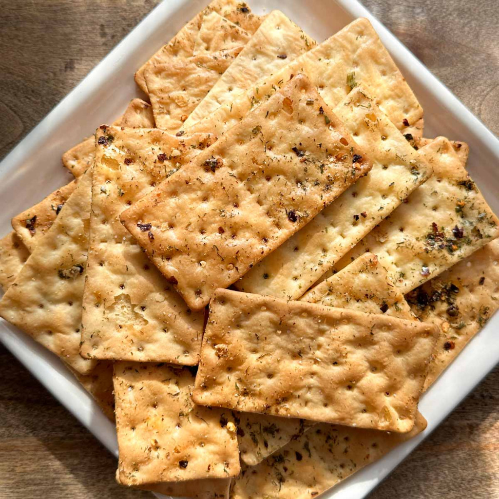 A serving plate of hot crackers that are gluten-free and baked with a spicy seasoning mix.