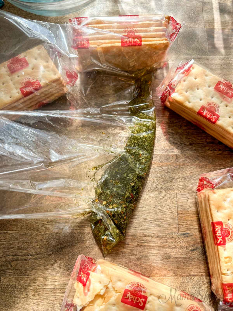 Packages of gluten-free saltines and a bag with spices and olive oil to make hot crackers.