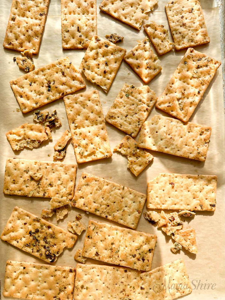 Freshly baked hot crackers on a parchment-lined baking pan.