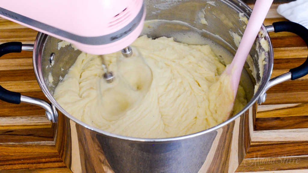 Mixing mashed potatoes with a hand mixer.
