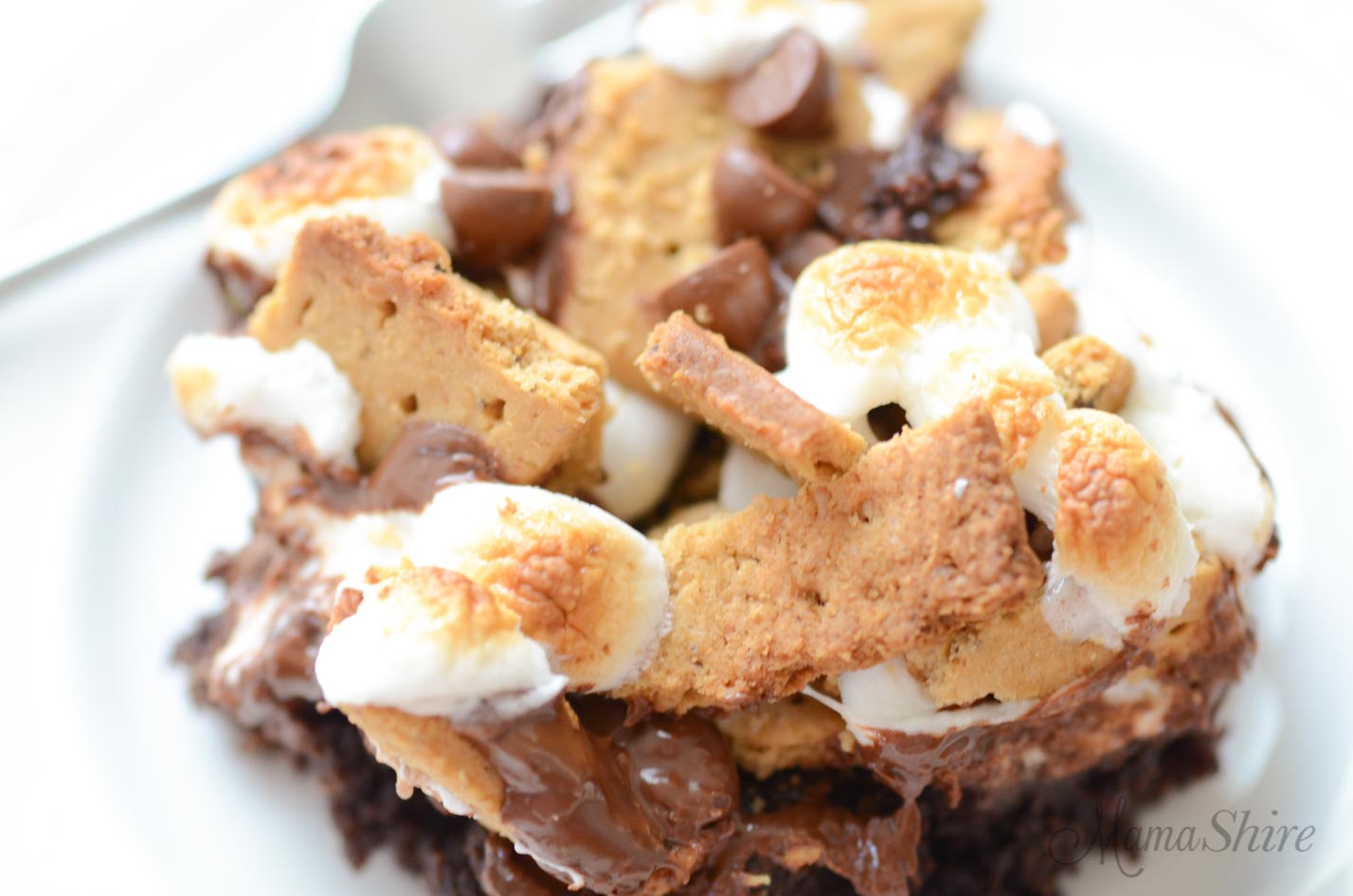 A closeup picture of gluten-free s'mores brownesi topped with graham crackers, marshmallows, and chocolate chips.