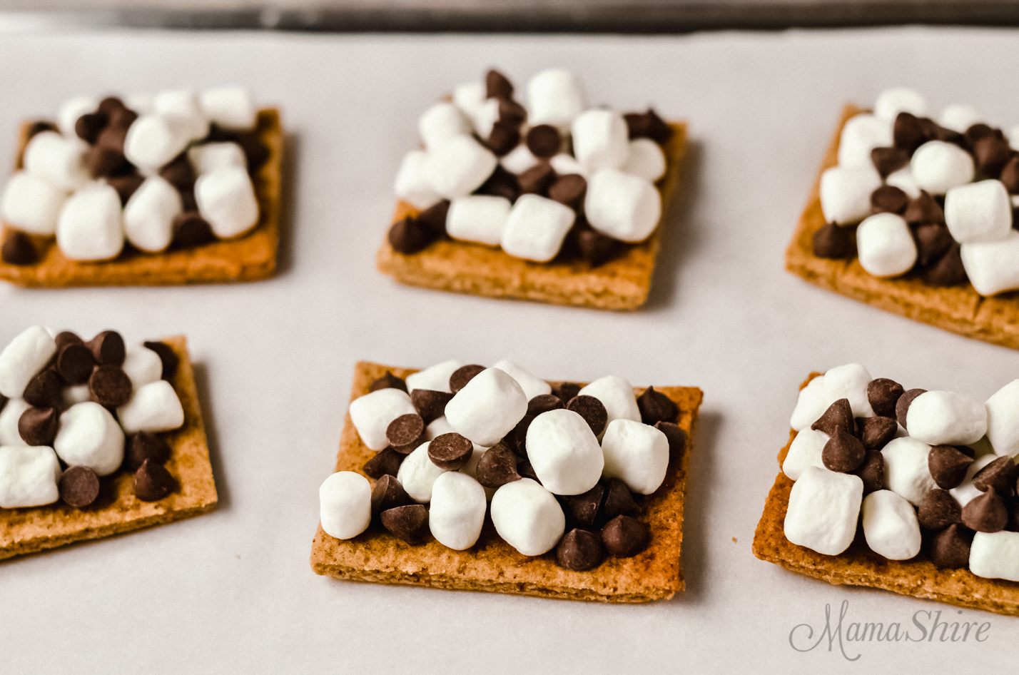Chocolate chips and mini marshmallows on top of a gluten-free graham cracker.