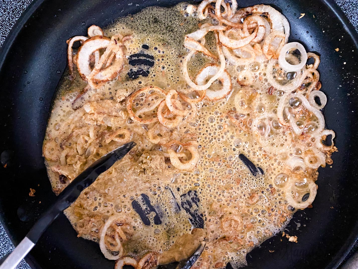 Onions frying in a skillet with just a bit of chicken broth.