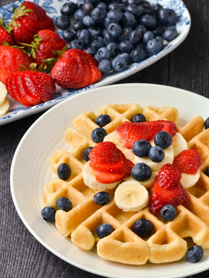 Waffles with bananas, strawberries, and blueberries.