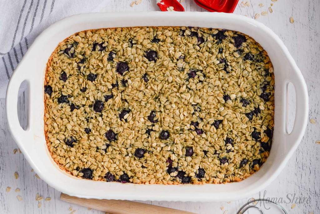 Baked oatmeal with blueberries baked in a white baking dish.