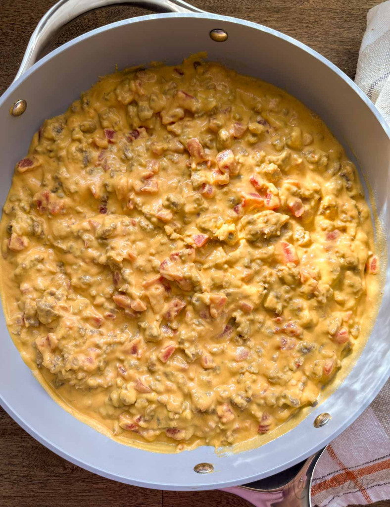 A skillet full of rotel dip that is made with dairy-free nacho cheese, rotel, and sausage.