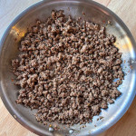 Italian Beef Sausage in a stainless steel skillet.