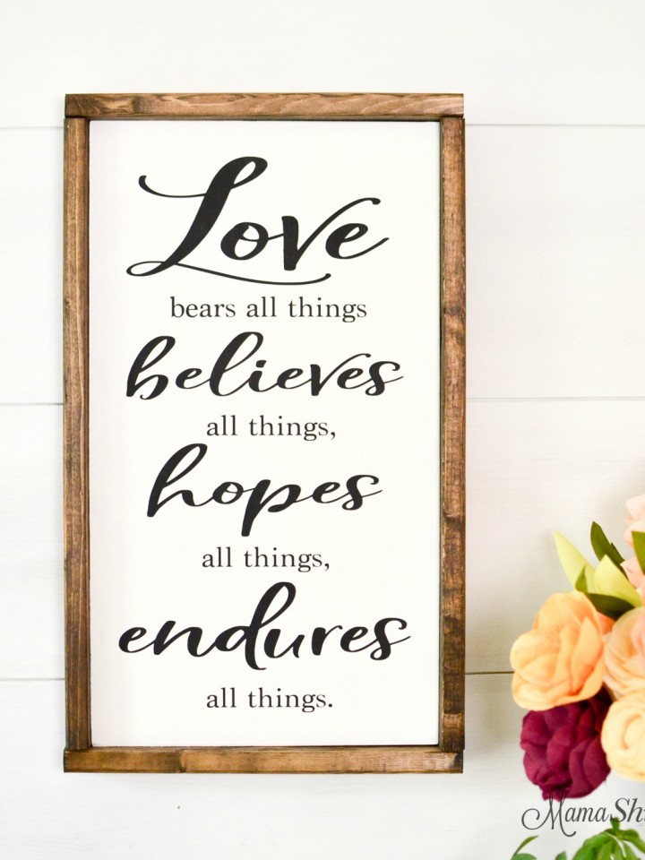 Love Bears All Things wooden sign with flowers.