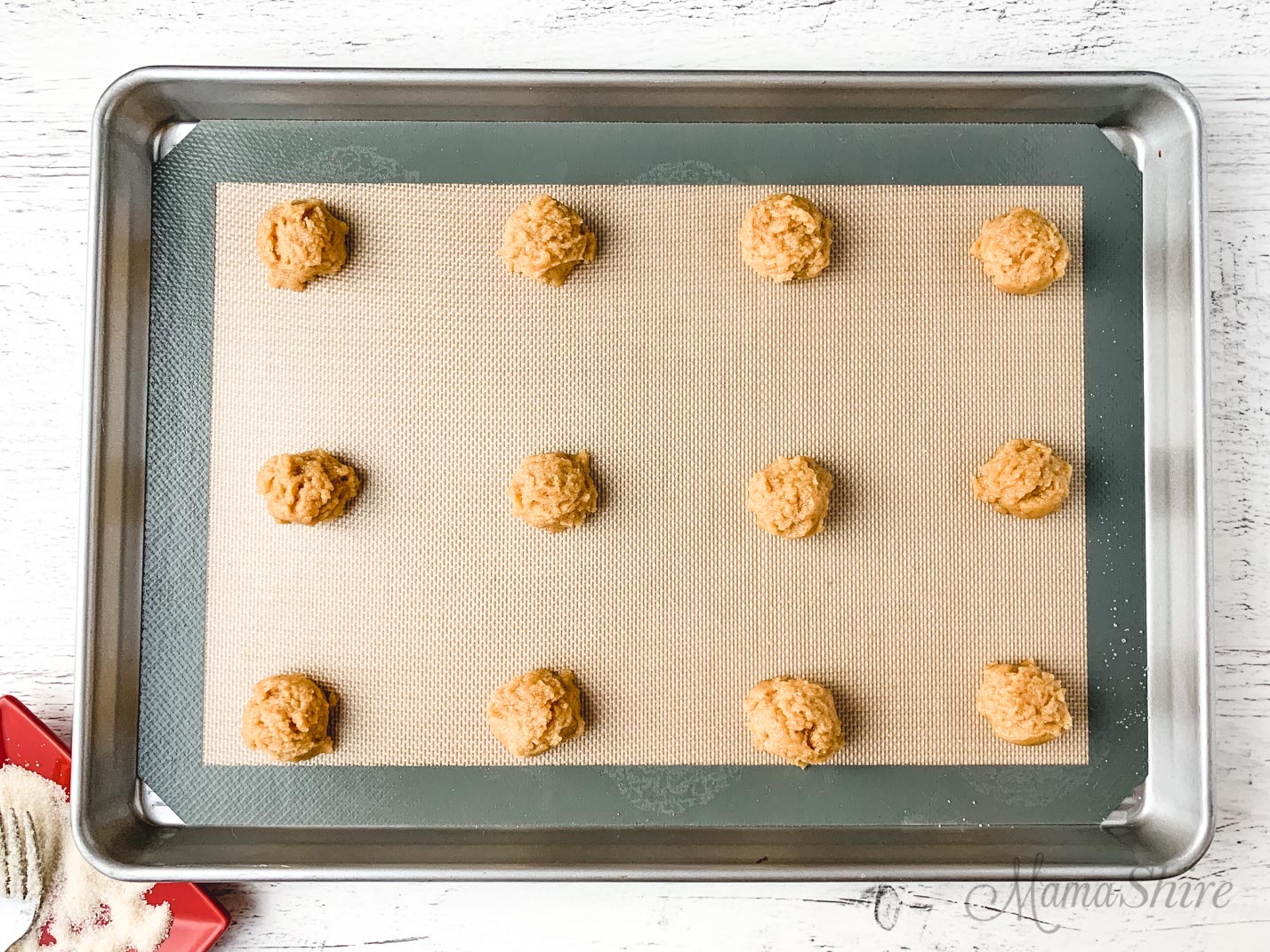 Peanut butter cookie dough on a baking sheet.