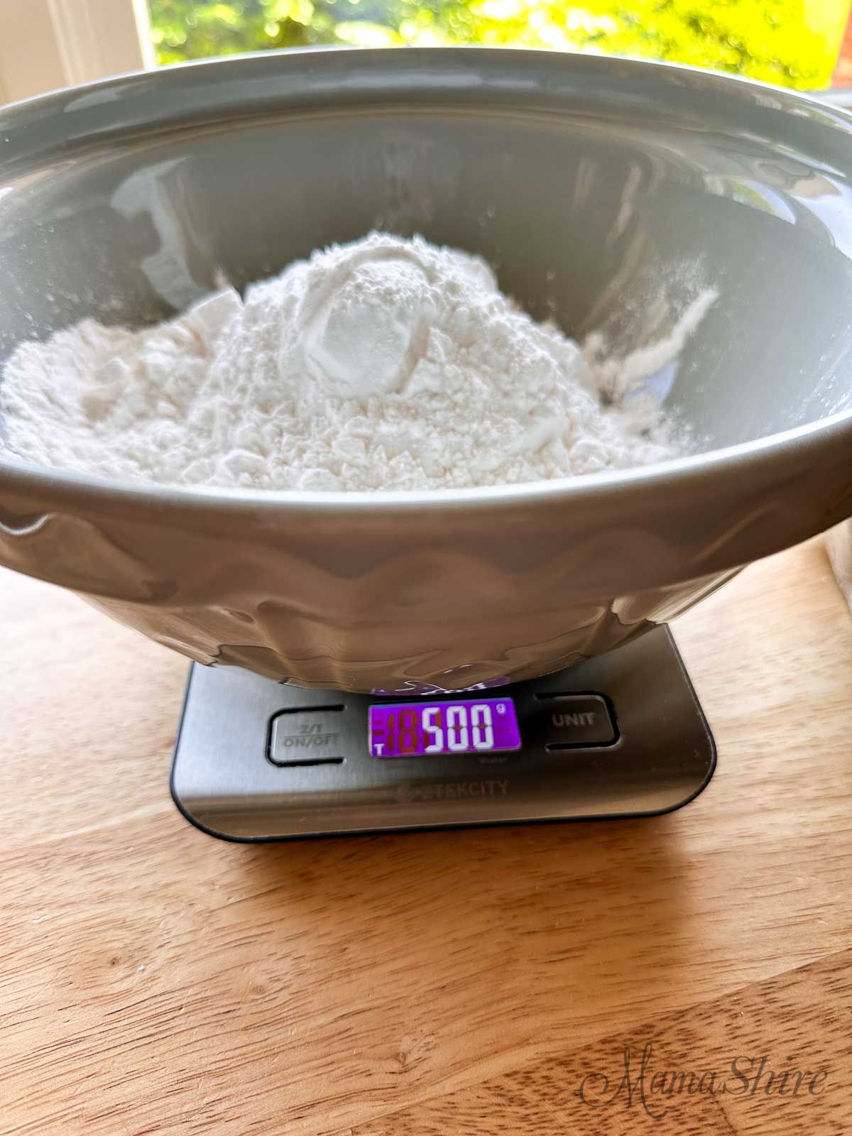 A large grey mixing bowl on top of a food scale with organic tapioca starch in it weighing 500 grams.