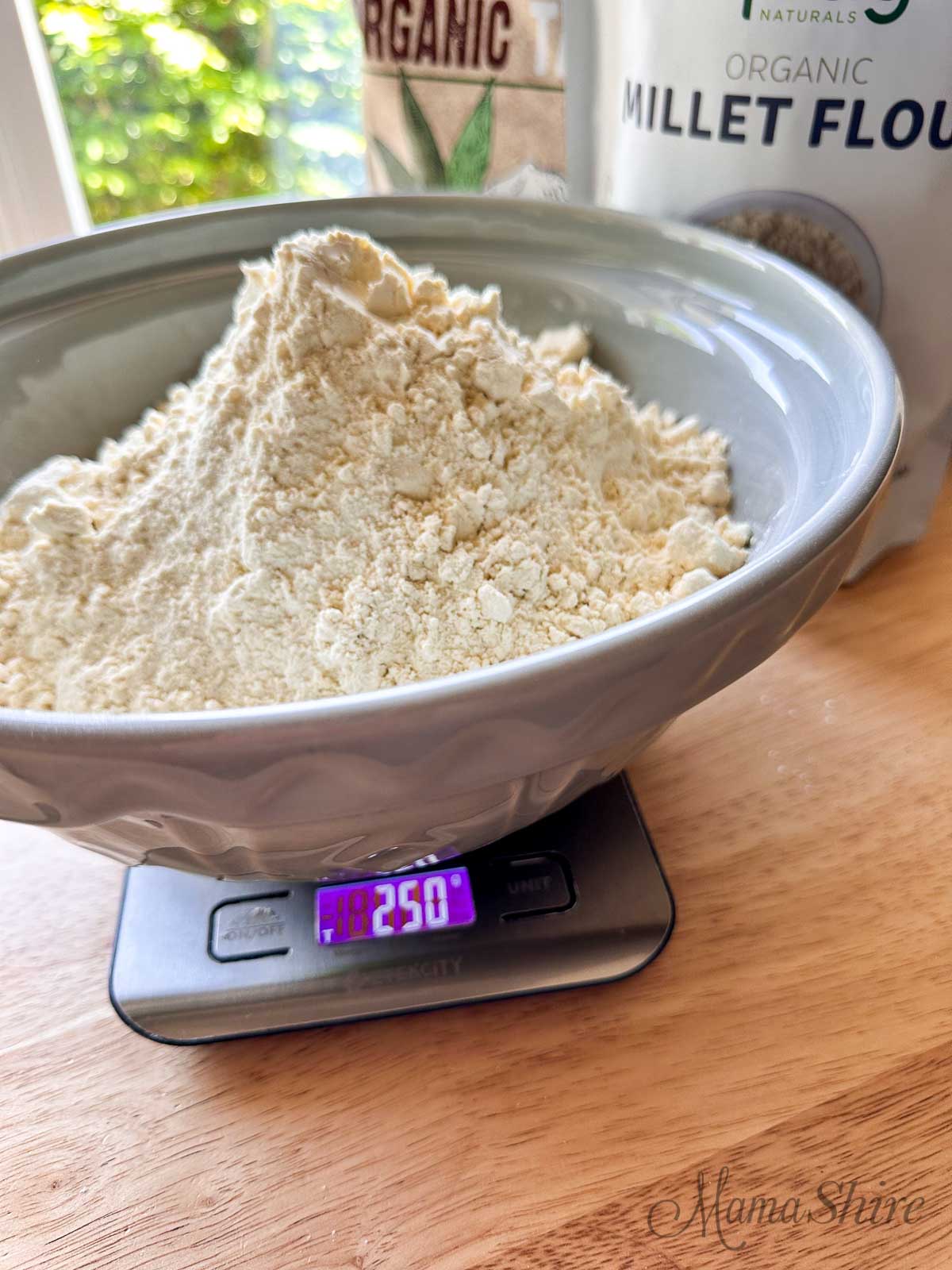 Organic millet flour in a grey mixing bowl that also has organic tapioca starch and organic millet flour. 