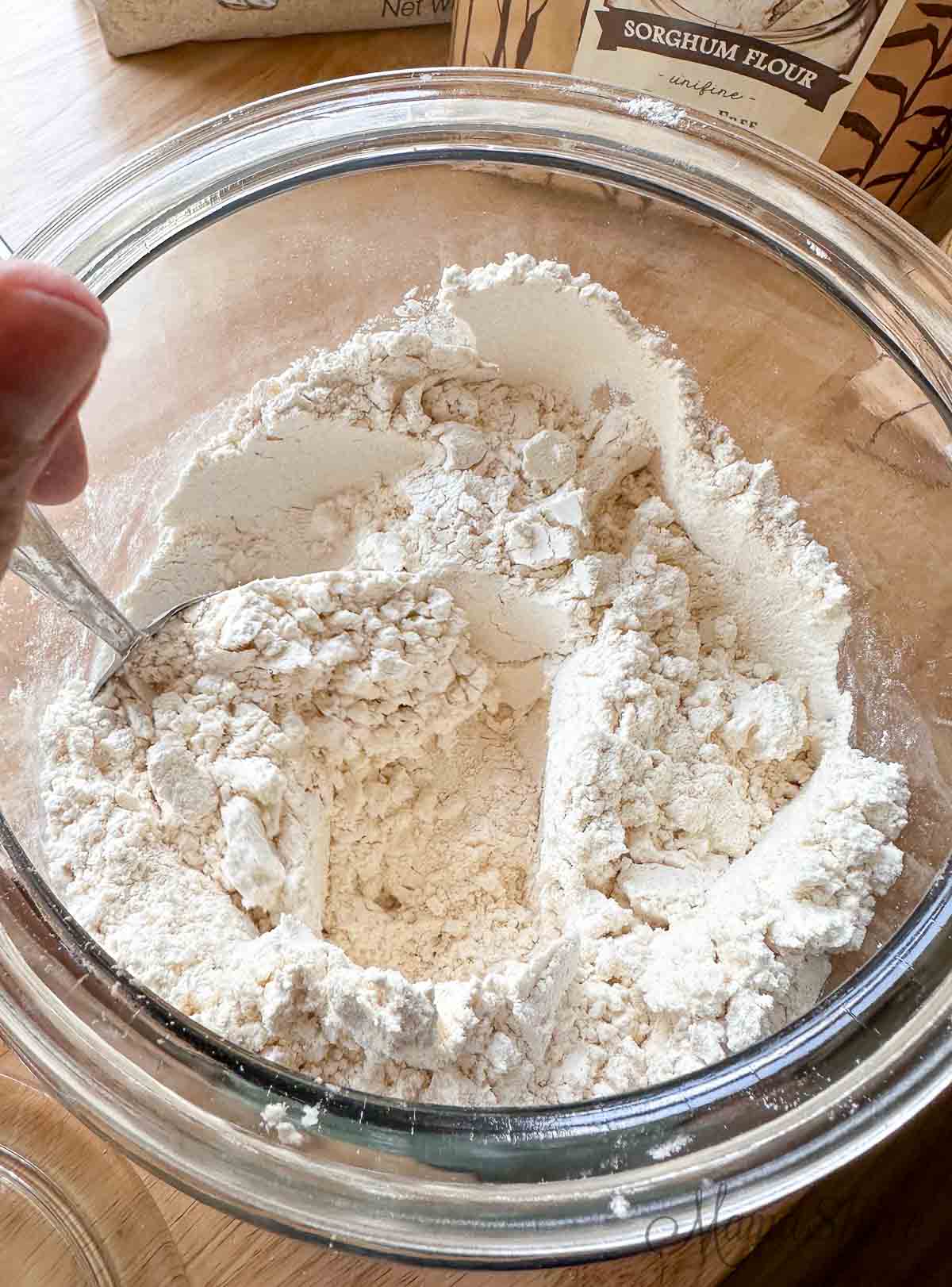 Organic gluten-free flour mix in a large glass storage container.