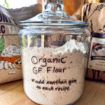 A glass gallon jar of organic gluten-free flour mix.