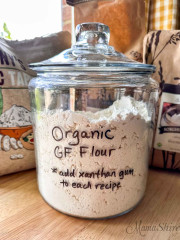 A glass gallon jar of organic gluten-free flour mix.