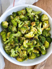 A serving bowl filled with roasted broccoli.