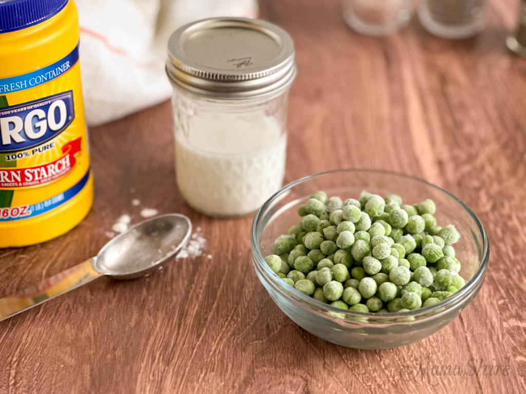 Mixing cornstarch and water in a pint jar to add to beef stew to thicken the broth with a cup of frozen peas to add as well. 