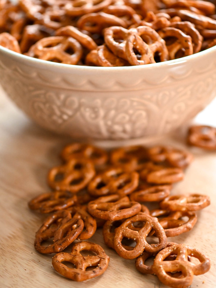 Spicy pretzels in a large serving bowl with some of them spilling out onto the counter.