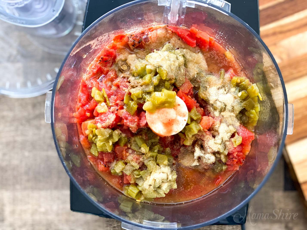 Tomatoes, chiles, and other ingredients in a food processor to make an easy homemade salsa. 