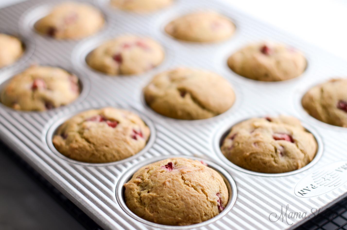 Freshly baked strawberry muffins still in the muffin pan.