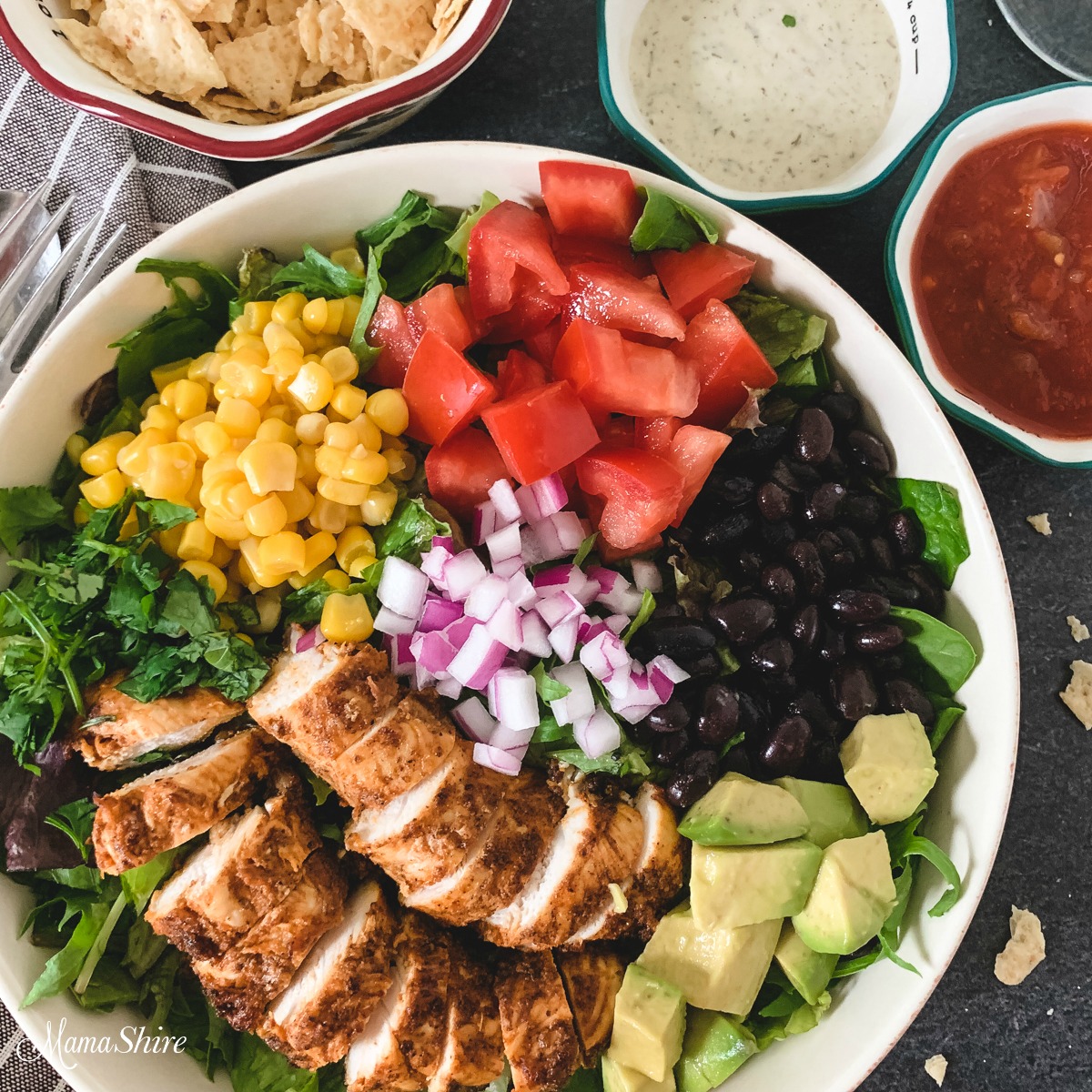 A colorful platter of taco salad with chicken made with black beans and corn.